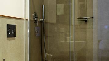 Un bagno moderno con doccia vetrata, un water e un lavandino.