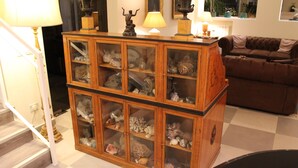 A wooden cabinet with glass doors displaying various decorative items. - Villa Abbamer (Grottaferrata)