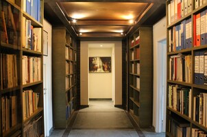 Una biblioteca con estanterías a ambos lados y un cuadro en la pared.