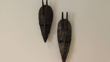 Deux sculptures en bois fixées sur un mur sobre.