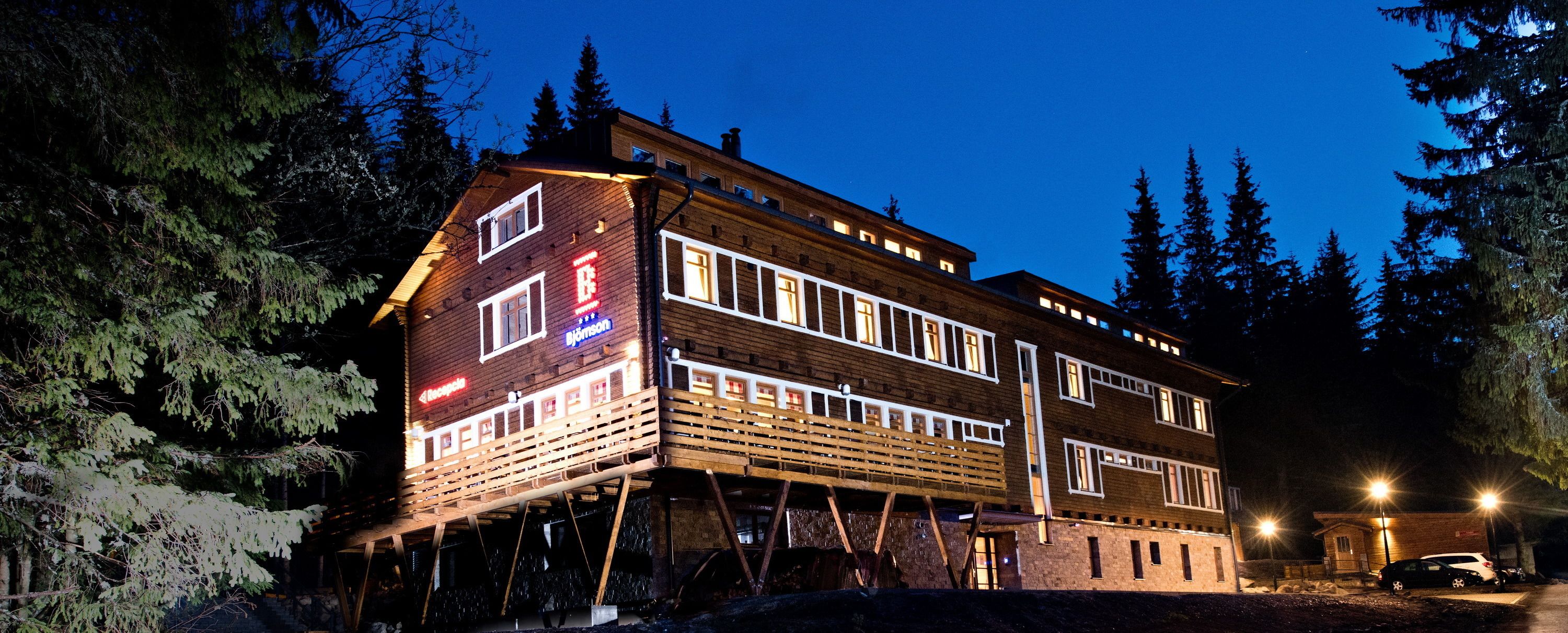 A multi-story building with a reception area, wooden facade, and multiple windows.