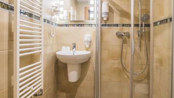 Un baño moderno con ducha acristalada, lavabo e inodoro.