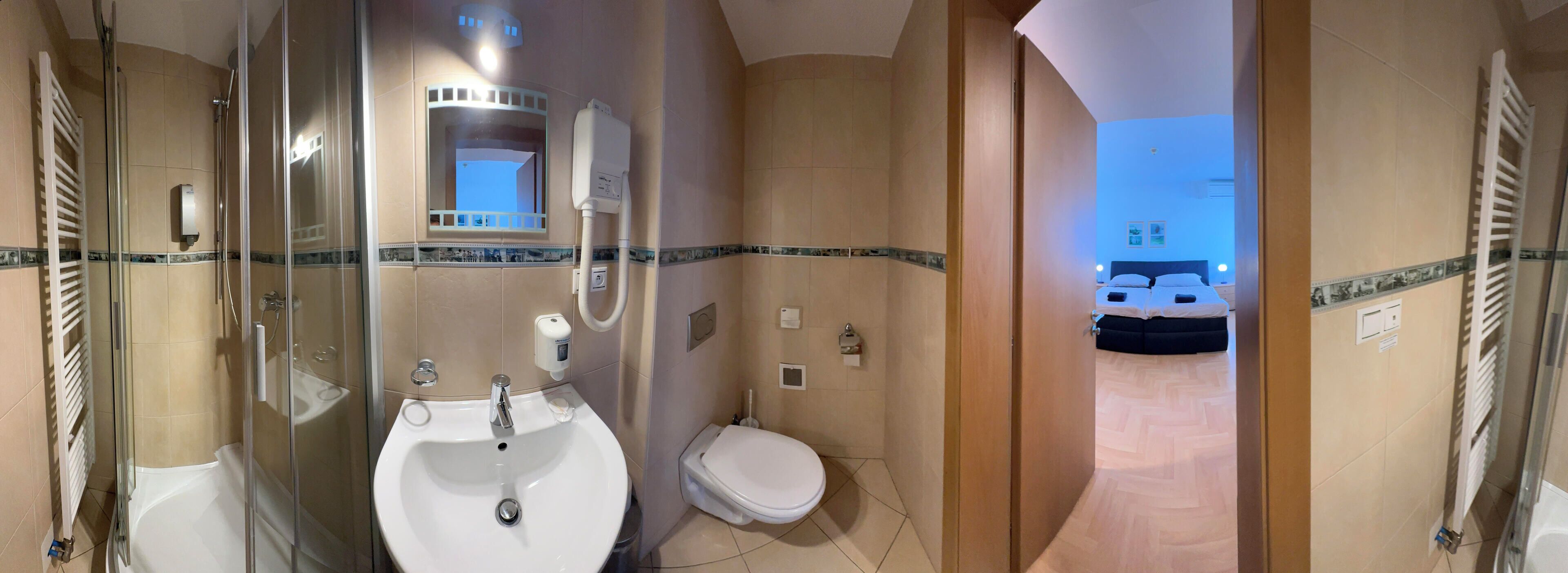 A modern bathroom with a glass-enclosed shower, a white sink, and a toilet.