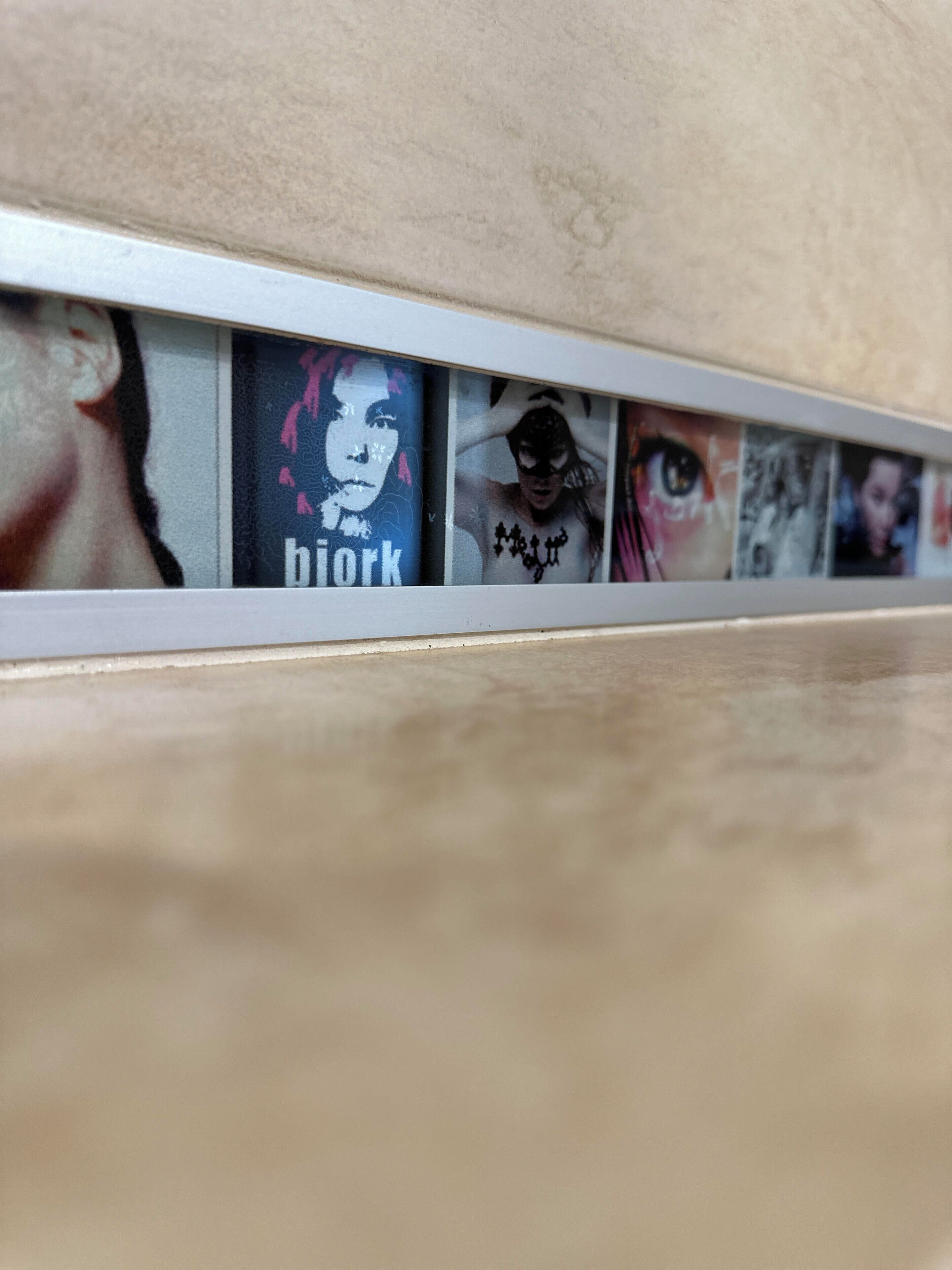 A series of framed artworks on a wall.