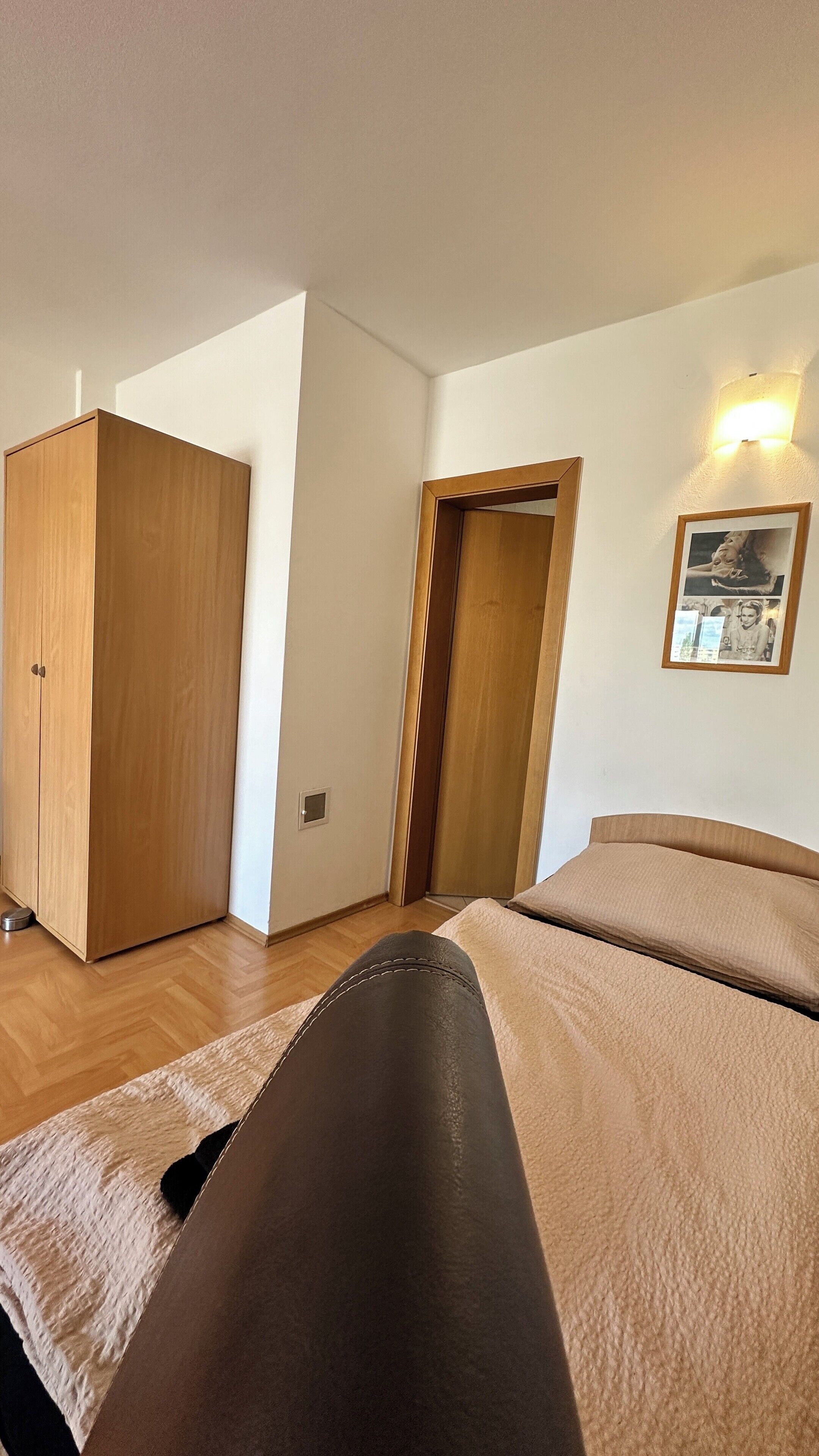 Un dormitorio con cama, armario y puerta.