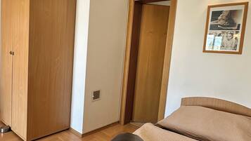 Un dormitorio con cama, armario y puerta.