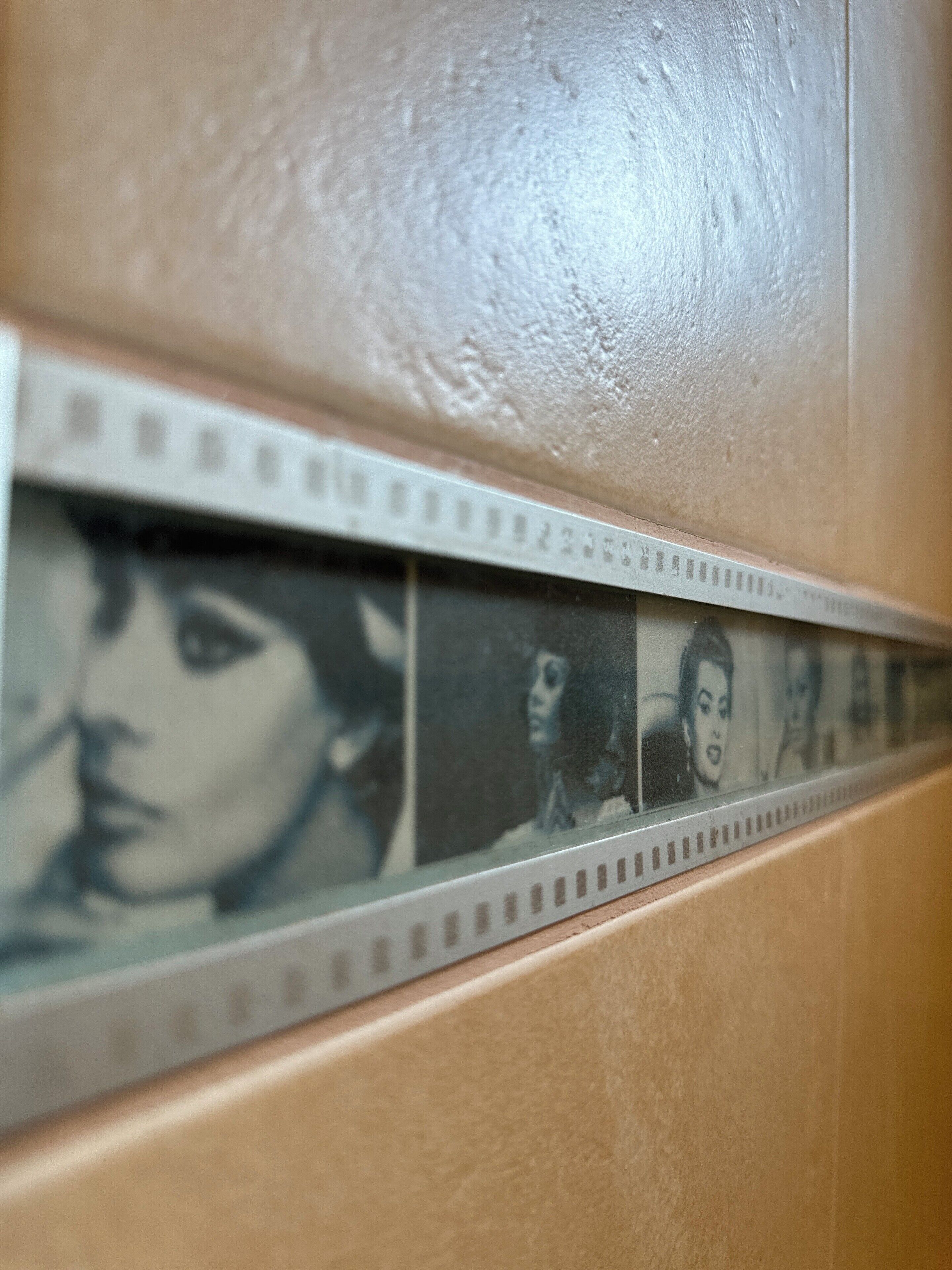 Un primo piano di un muro con una striscia di negativi cinematografici.