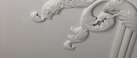 A close-up of a white decorative molding with intricate scrollwork.