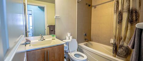 A bathroom with a sink, toilet, and bathtub.