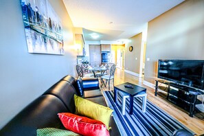A living room with a sofa, a coffee table, and a television. - Lake View Luxury Condo by Elite Suites (Mississauga)
