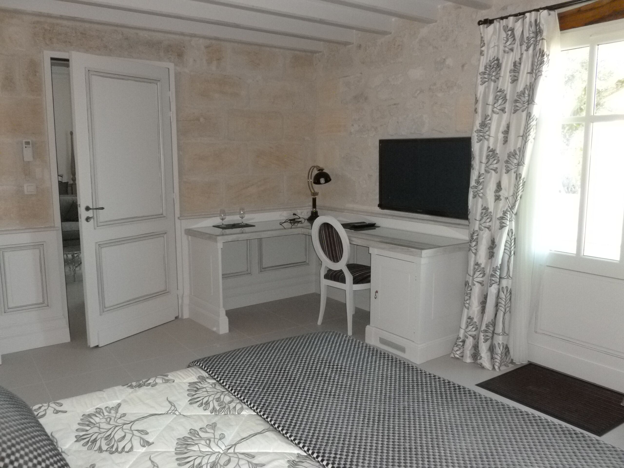 Une chambre à coucher comprenant un lit, un bureau, une chaise, un téléviseur et une armoire.