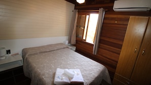 Une chambre à coucher avec un lit, une table de chevet avec une lampe et une armoire.