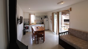 Une cuisine compacte avec une table à manger, des chaises, un canapé et une vue sur l’extérieur.
