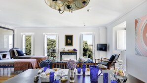 A dining room with a large table set for a meal, a chandelier, and a view of the outdoors.