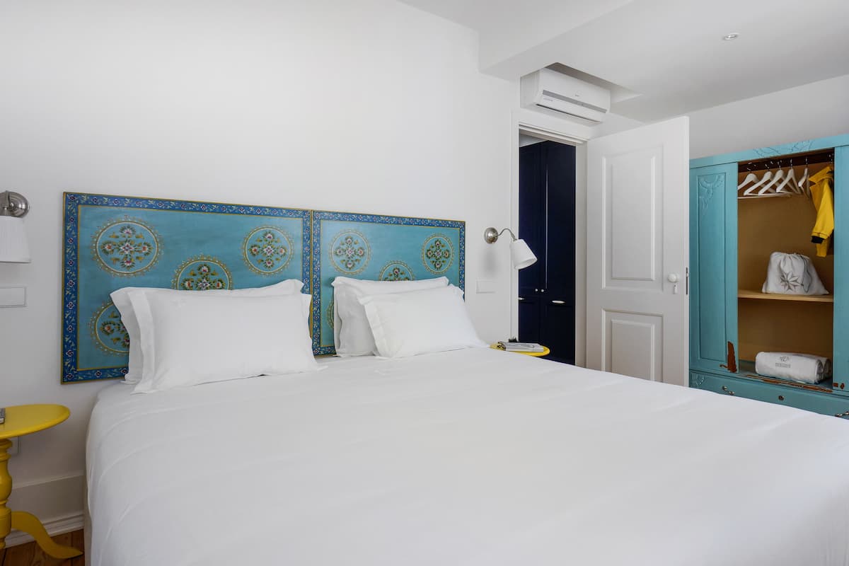 Une chambre d’hôtel avec un grand lit, une armoire et une table de chevet.
