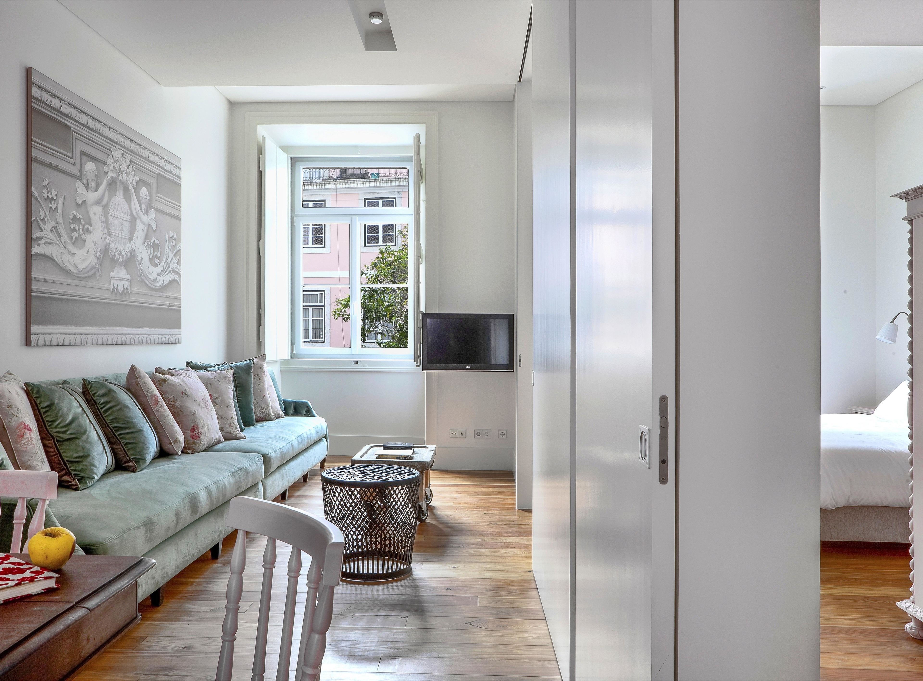 A modern living room with a sofa, a small round table, and a television.