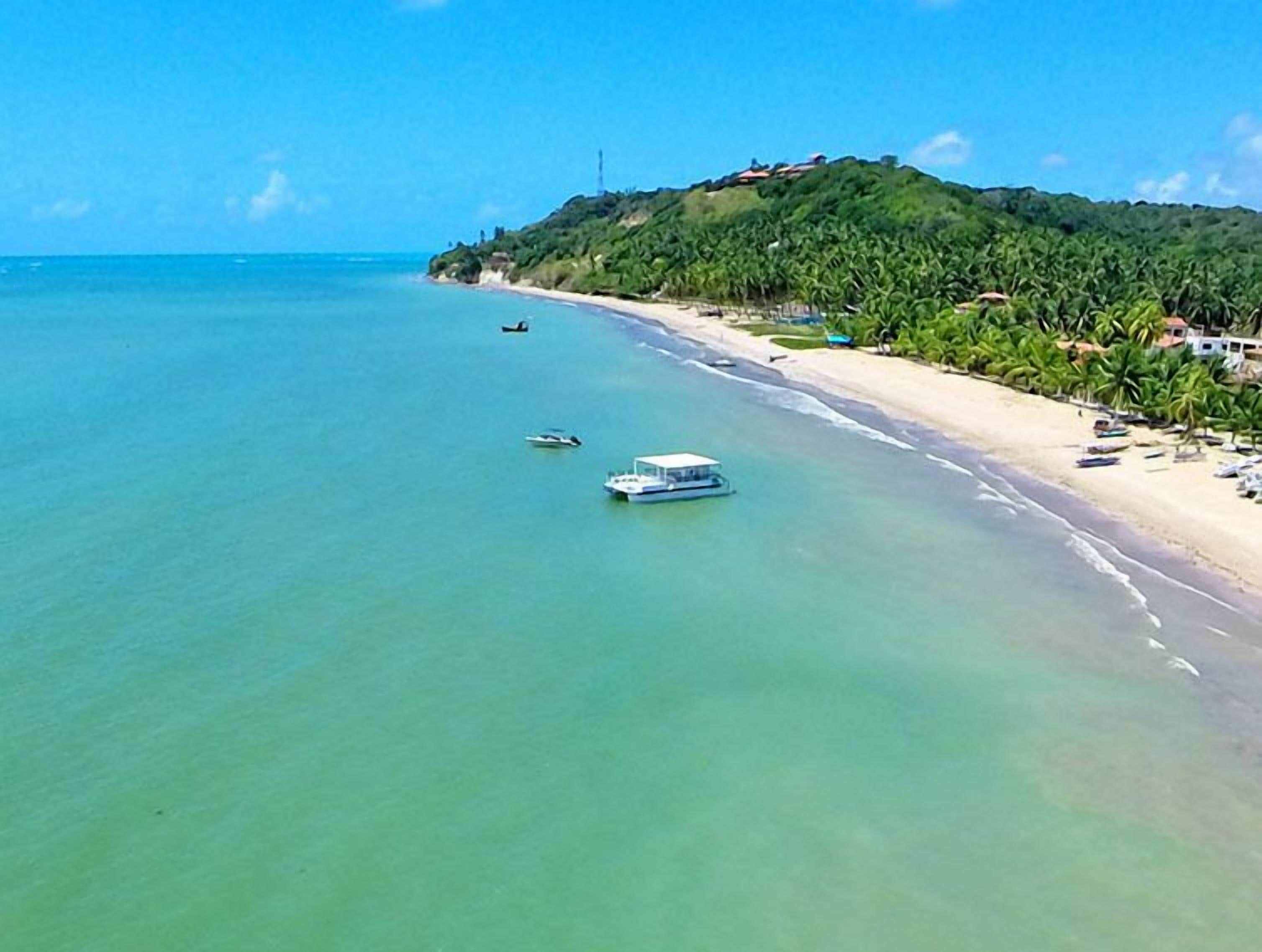 Na praia, areia branca, espreguiçadeiras, guarda-sóis 