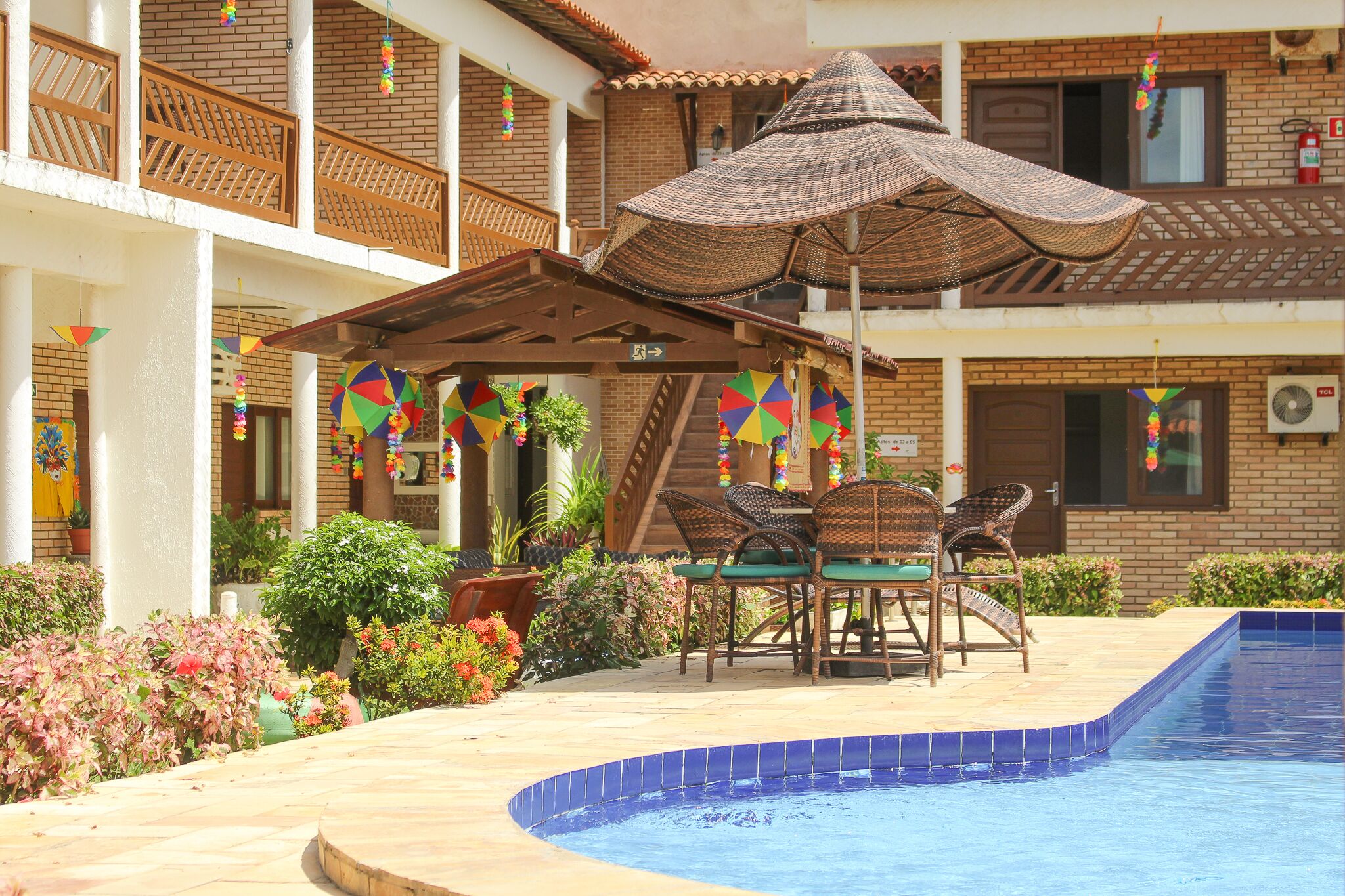 A poolside area with a covered seating area, a staircase, and a pool.