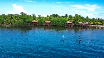 Un resort tropical con bungalows sobre el agua y una laguna azul cristalina.