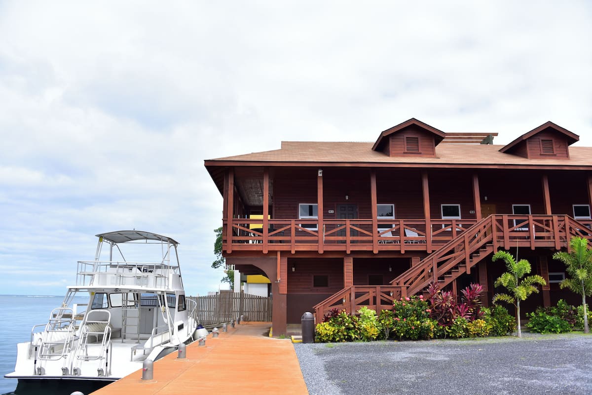 A wooden building with a balcony and a boat docked in front.