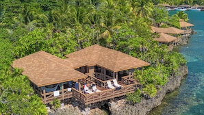 A coastal resort with wooden structures, clear turquoise water, and lush greenery. - Anthony's Key Resort (Roatan)