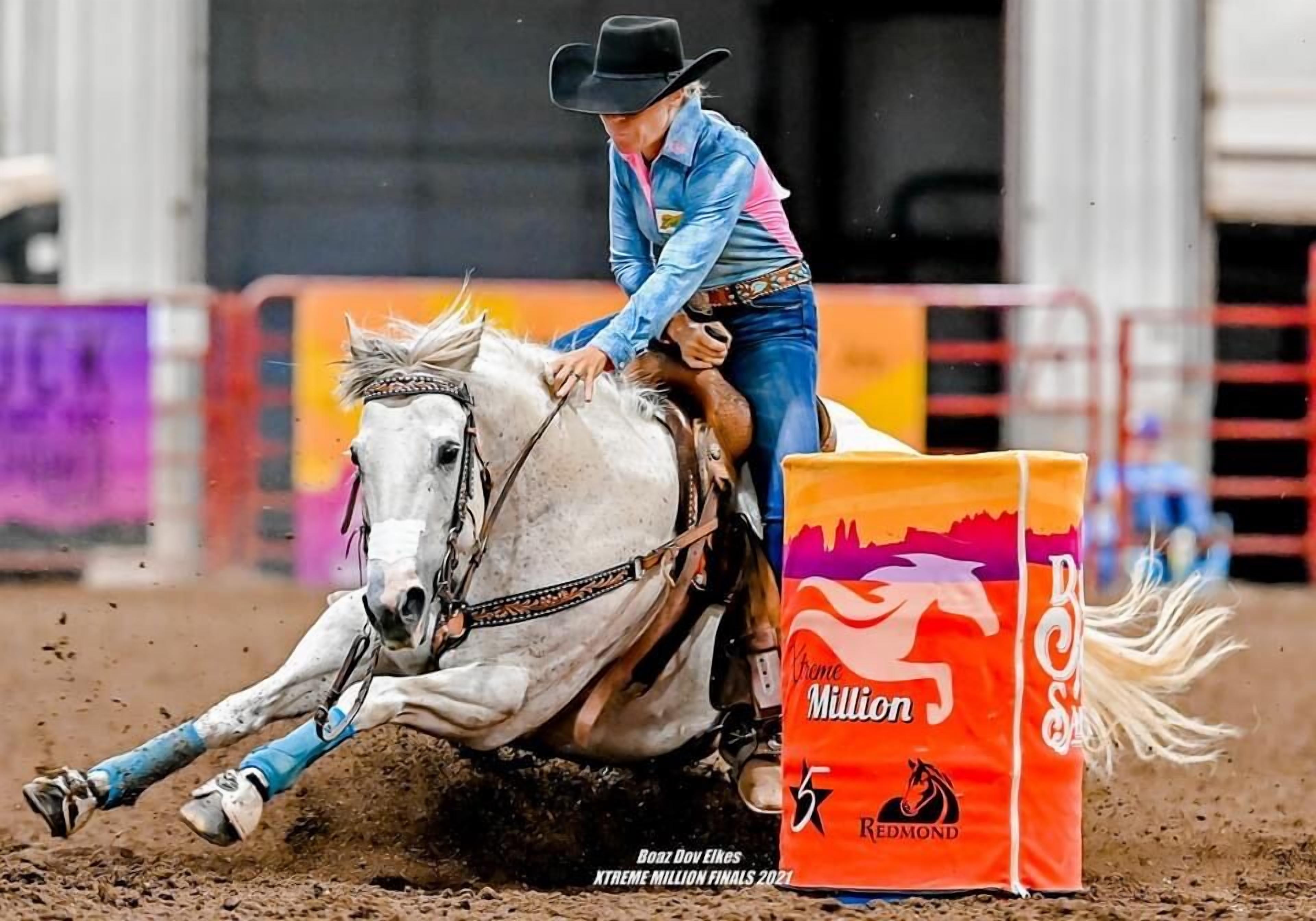 Une personne à cheval lors d'un événement, avec une barrière portant l'inscription « Xtreme Million » au premier plan.