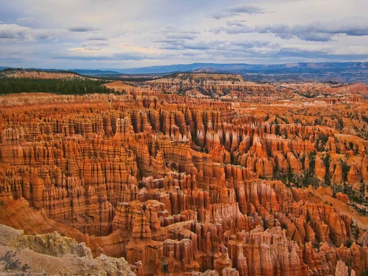A panoramic view of a rugged canyon landscape with layered rock formations.