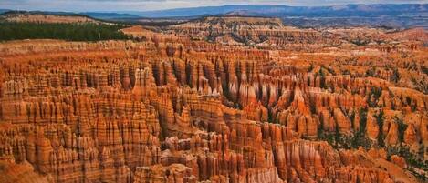 A panoramic view of a rugged canyon landscape with layered rock formations.