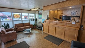 A reception area with a wooden counter, a couch, and a coffee table.