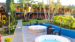 Uma área de piscina com duas banheiras de hidromassagem, cercada por uma parede azul e um caminho.