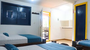 Quarto de hotel com duas camas, um guarda-roupa e uma porta que dá para uma varanda.