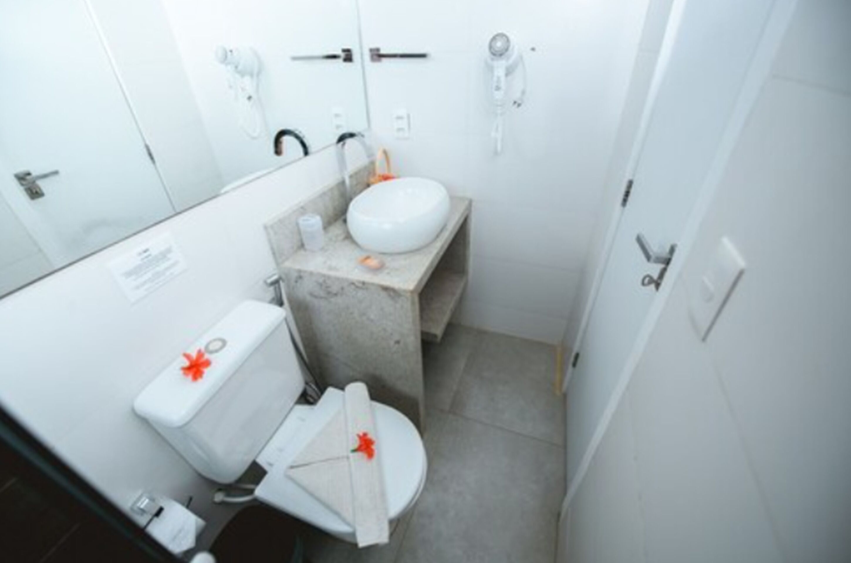 Un baño pequeño con inodoro, lavamanos y espejo.