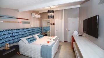 Quarto com cama, televisão e escrivaninha.