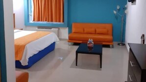 Una habitación con una cama, un sofá, una mesa de centro y un aparador.
