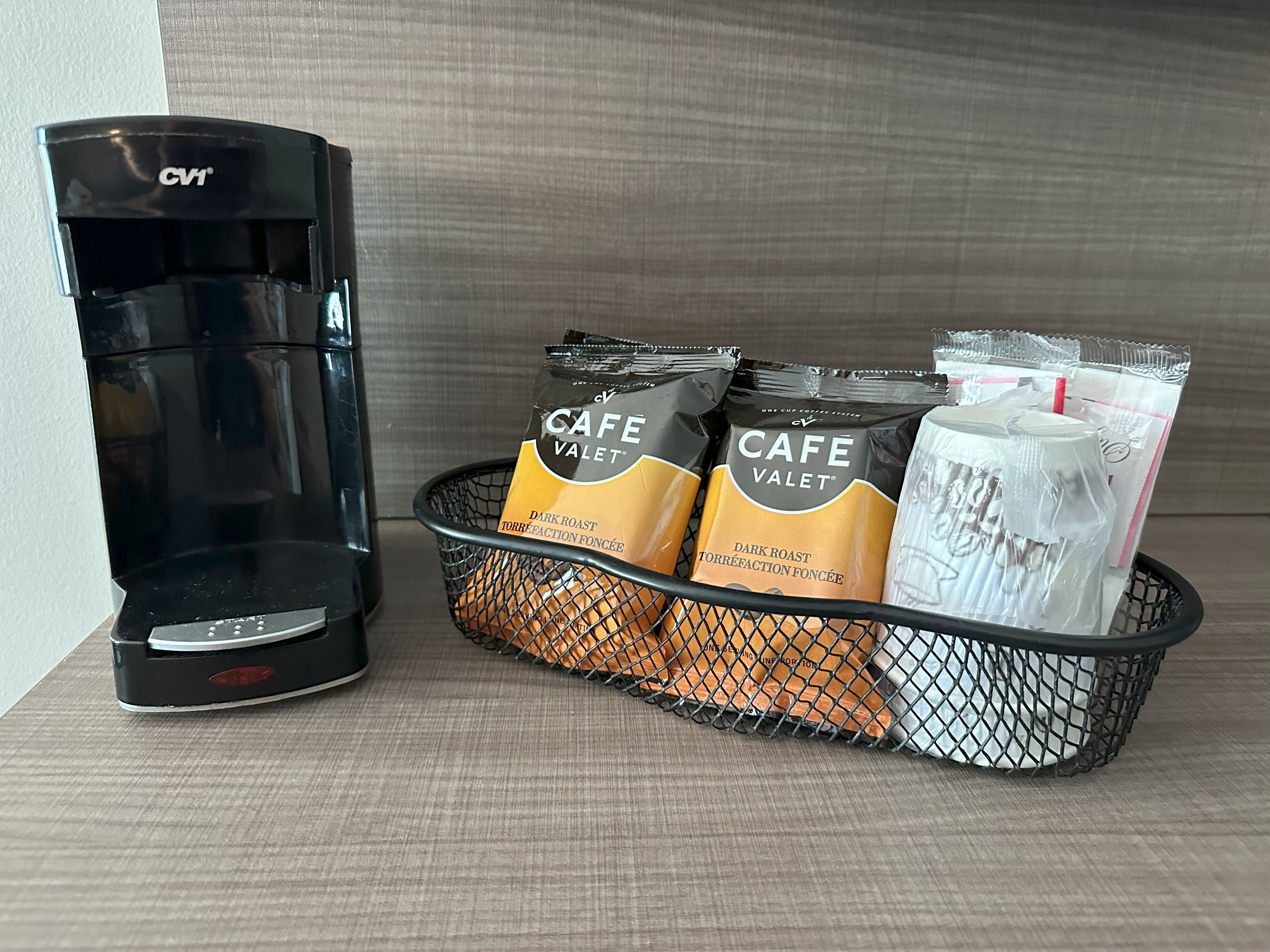 Une machine à café et un panier contenant des dosettes de café et un mousseur à lait.