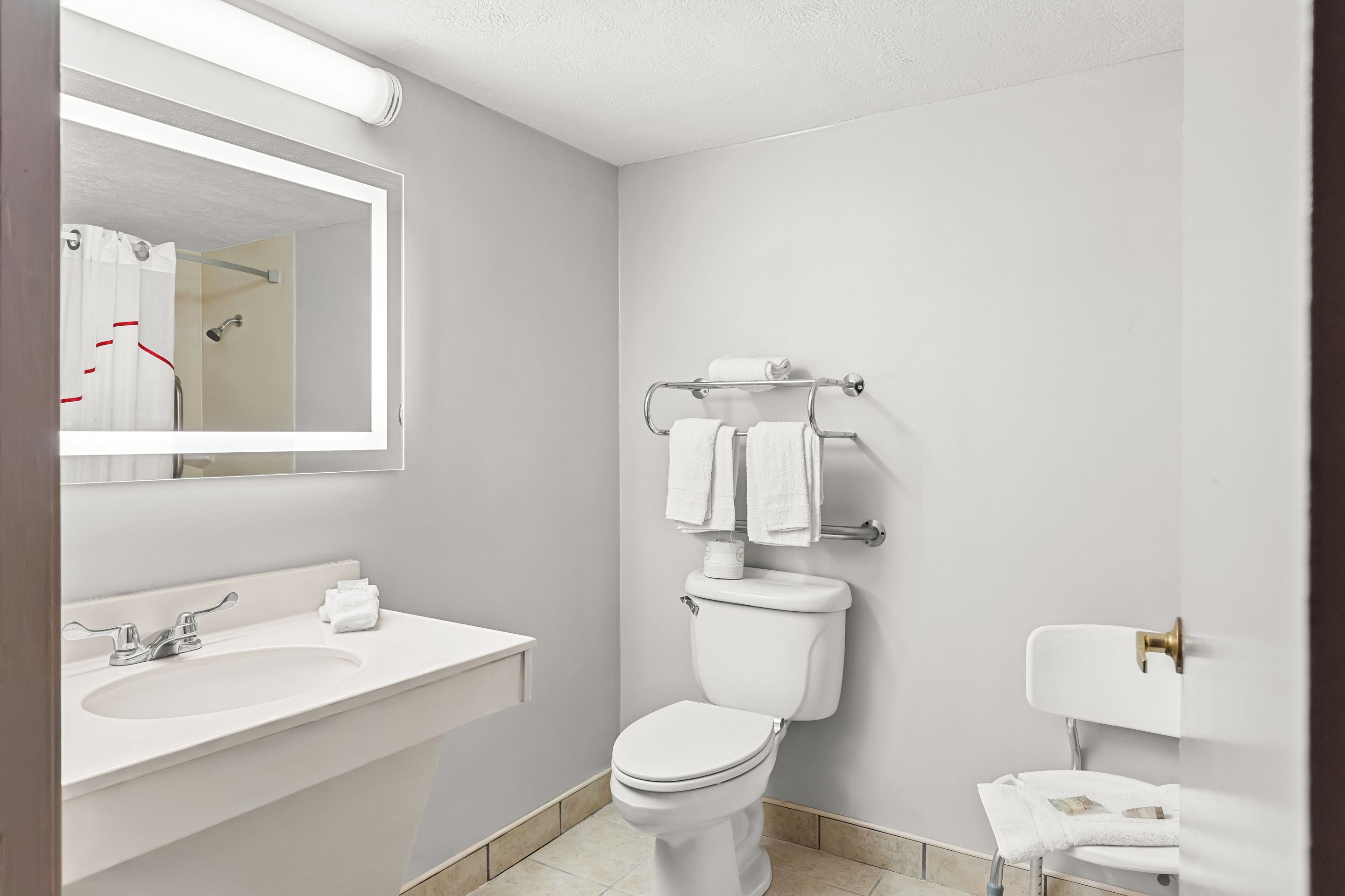 A modern bathroom with a white sink, toilet, and shower.