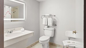 A modern bathroom with a white sink, toilet, and shower.