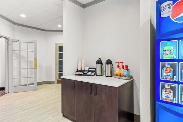 A reception area with a counter, coffee maker, and beverage dispensers. - Red Roof Inn Cambridge, OH (Cambridge)