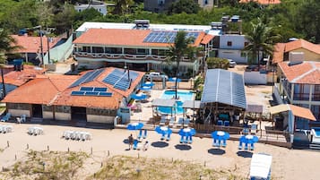 A resort with multiple buildings, a swimming pool, and beach chairs.
