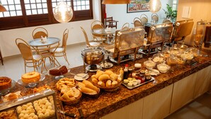 Zona tipo bufé con diferentes opciones de comida y mesas.