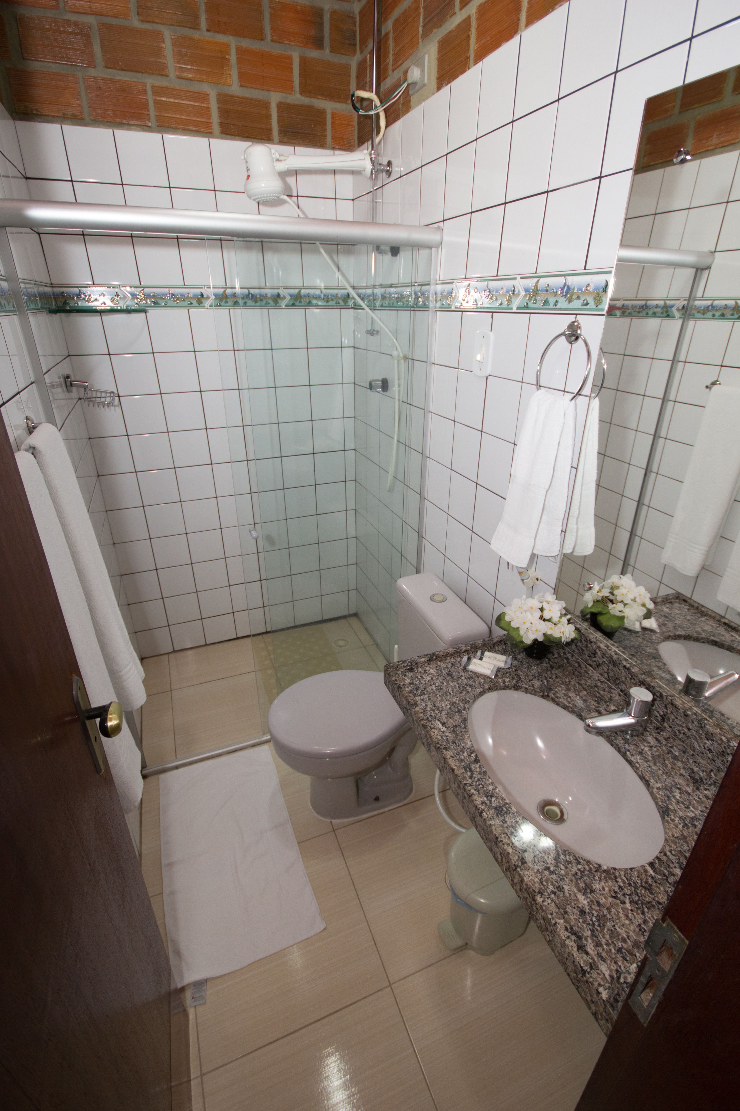 A bathroom with a toilet, sink, and shower.
