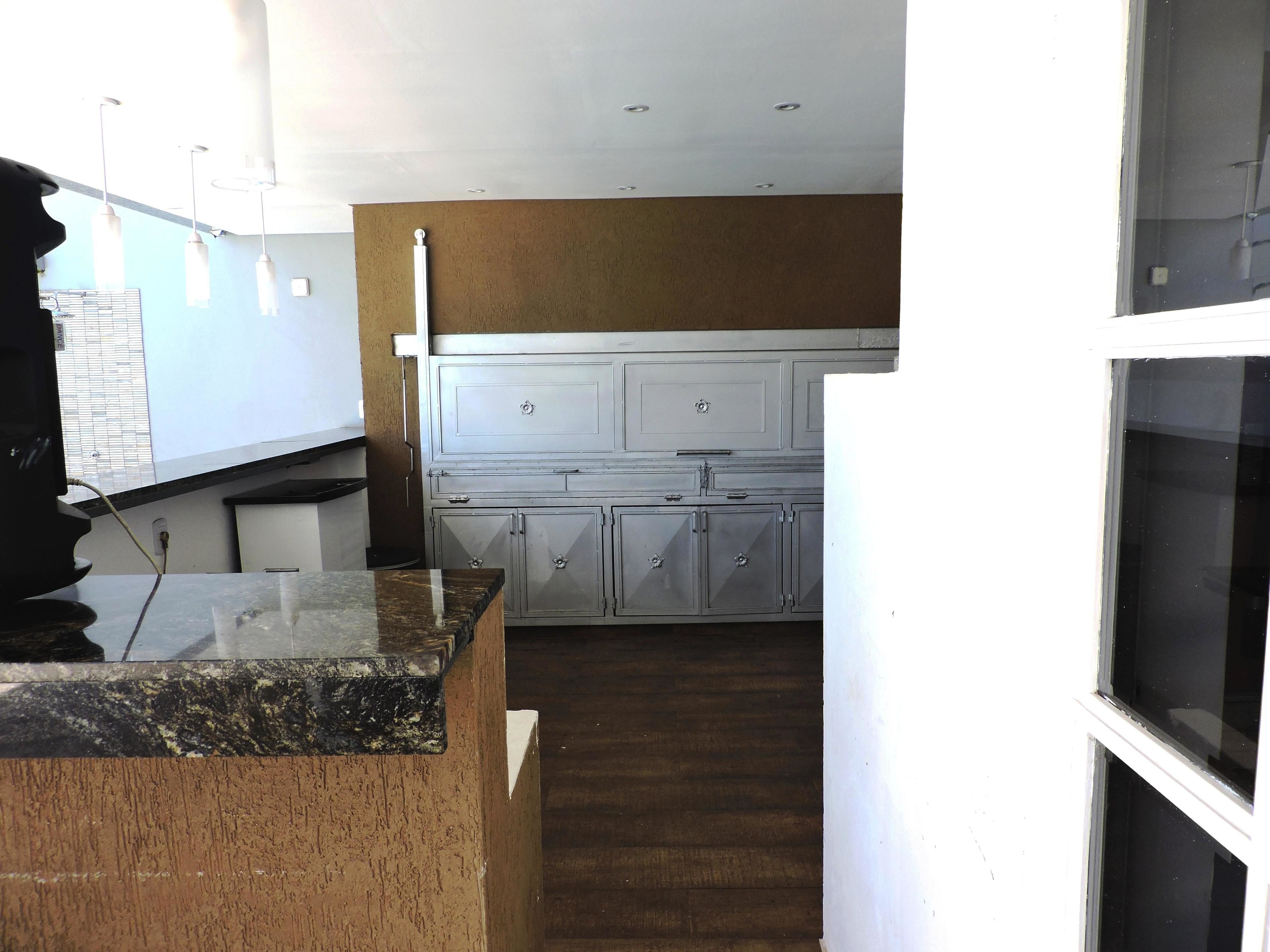 A kitchen with white cabinets, a granite countertop, and a wooden floor.