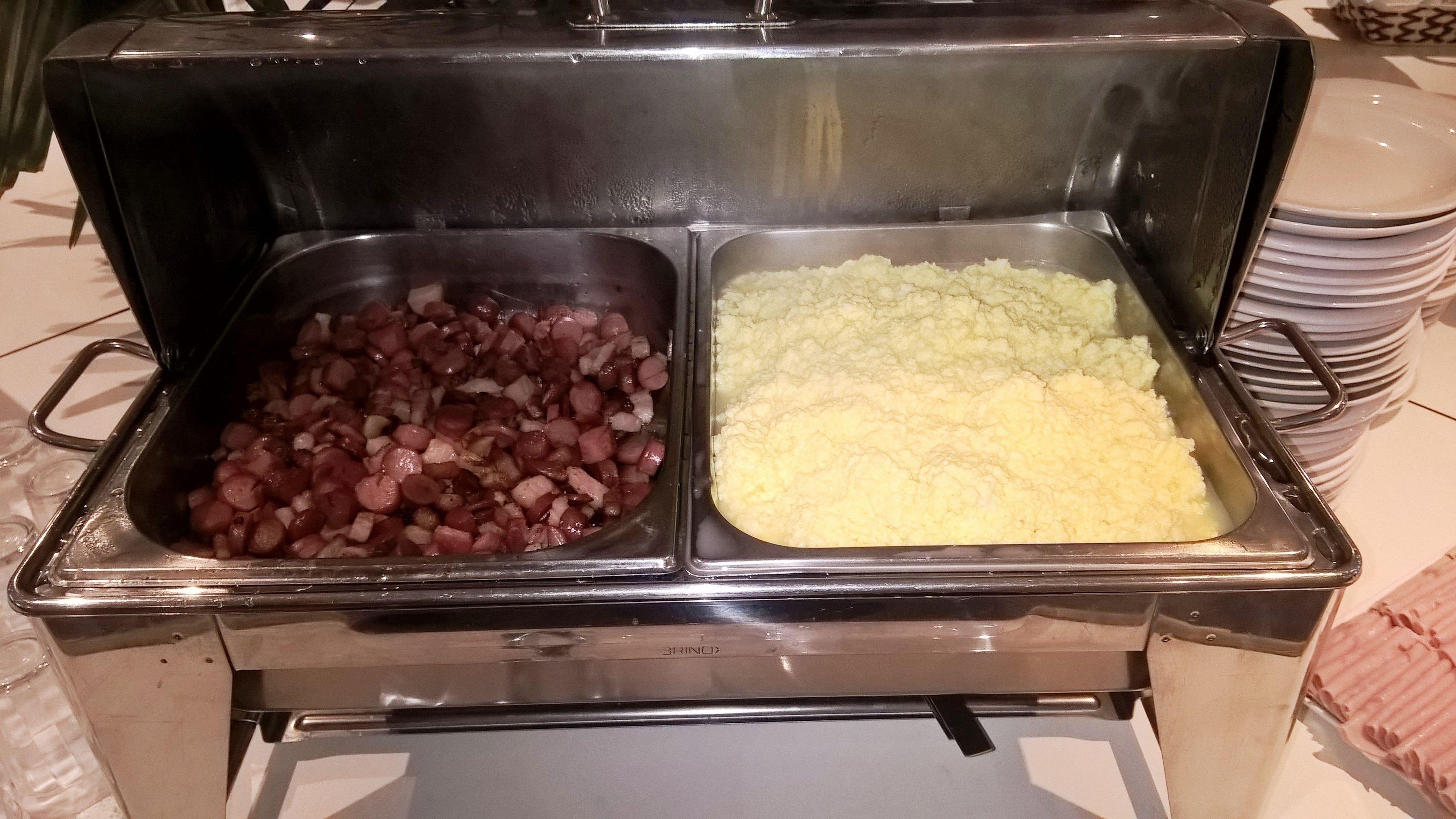 Un bufé con dos fuentes de comida: una con carne picada y otra con puré de papas.