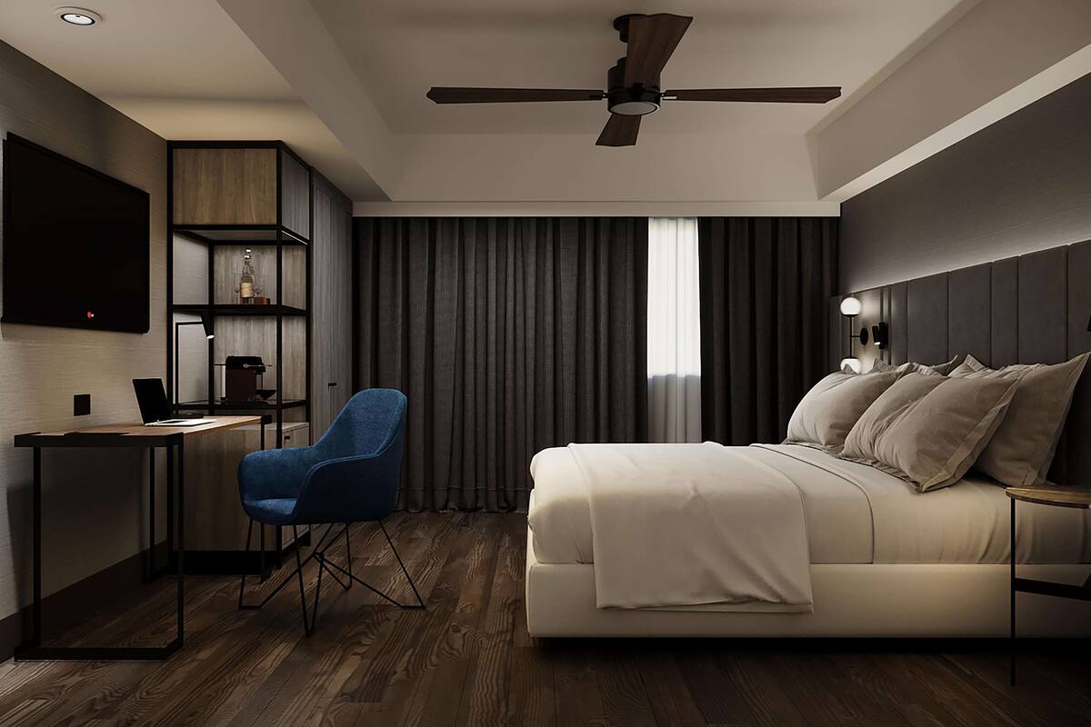 Ein modernes Schlafzimmer mit Bett, Schreibtisch, Stuhl, Deckenventilator und Fernseher.