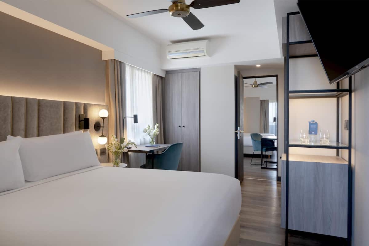 Ein modernes Hotelzimmer mit einem großen Bett, einem Schreibtisch und einer Sitzecke.