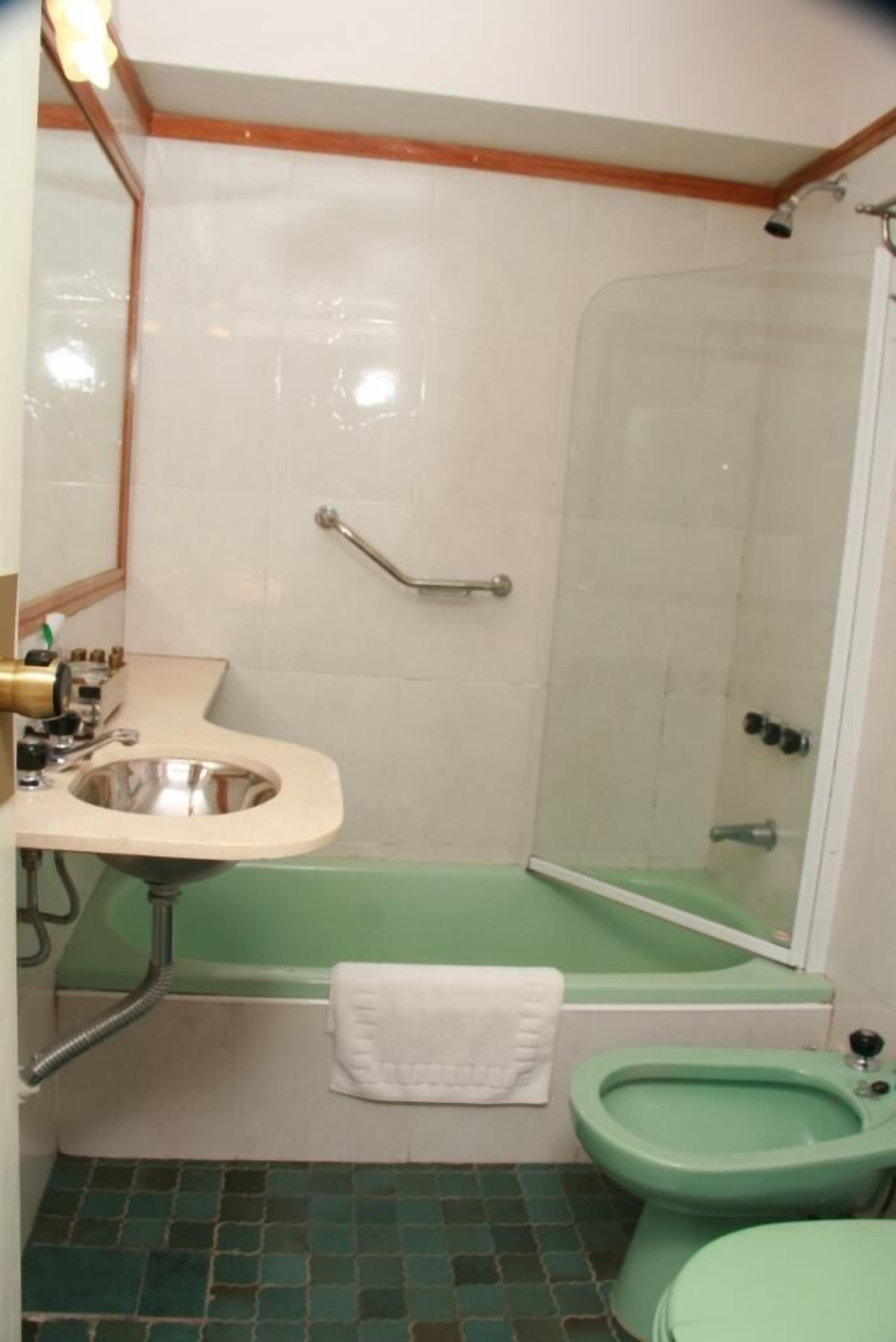 A bathroom with a sink, toilet, and shower.
