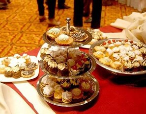 A multi-tiered dessert display with various pastries and cakes on a table.