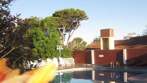 Zona de piscina con vista despejada a un edificio de hotel al fondo.