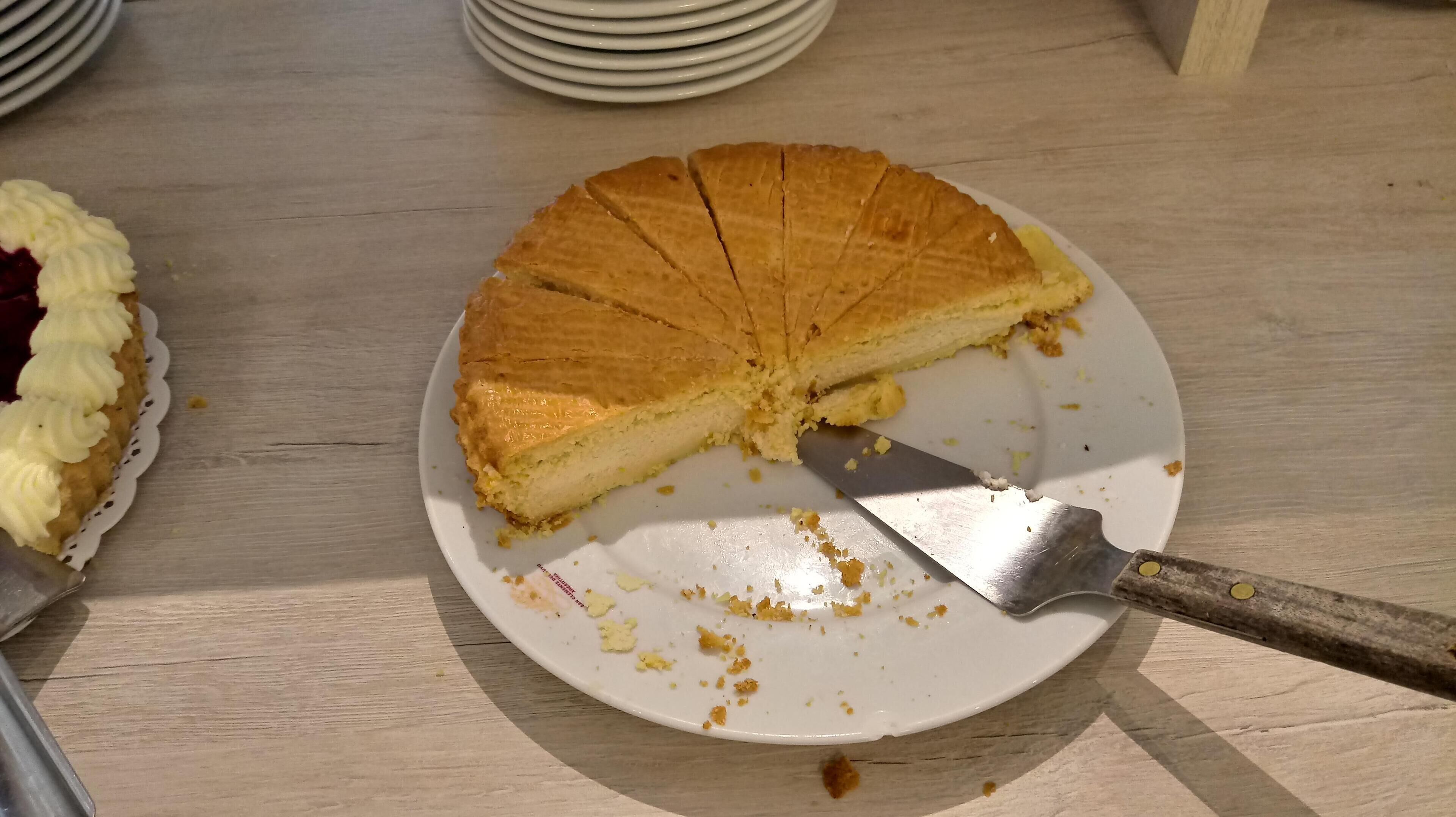 A pie with a slice missing on a white plate.