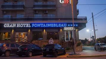 El Gran Hotel Fontainebleau, con una entrada visible, una estatua y un letrero para el Restaurante Degli Avvisi.